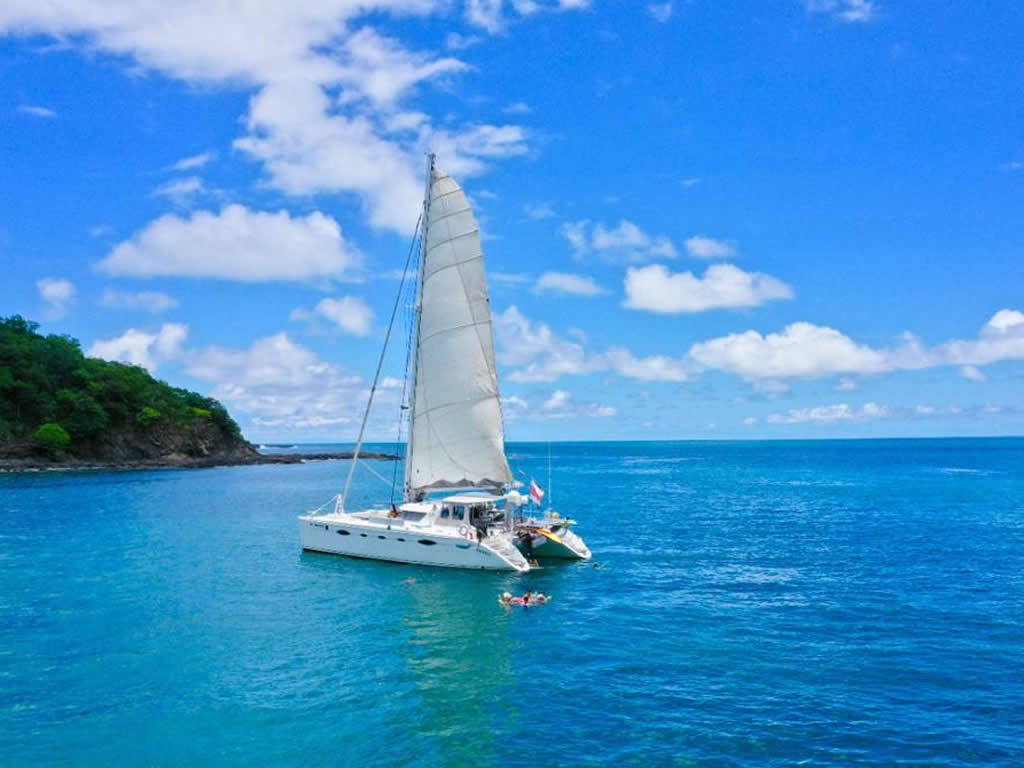 Catamaran Tours Papagayo Why Not boat anchored in calm, turquoise water on a sunny day